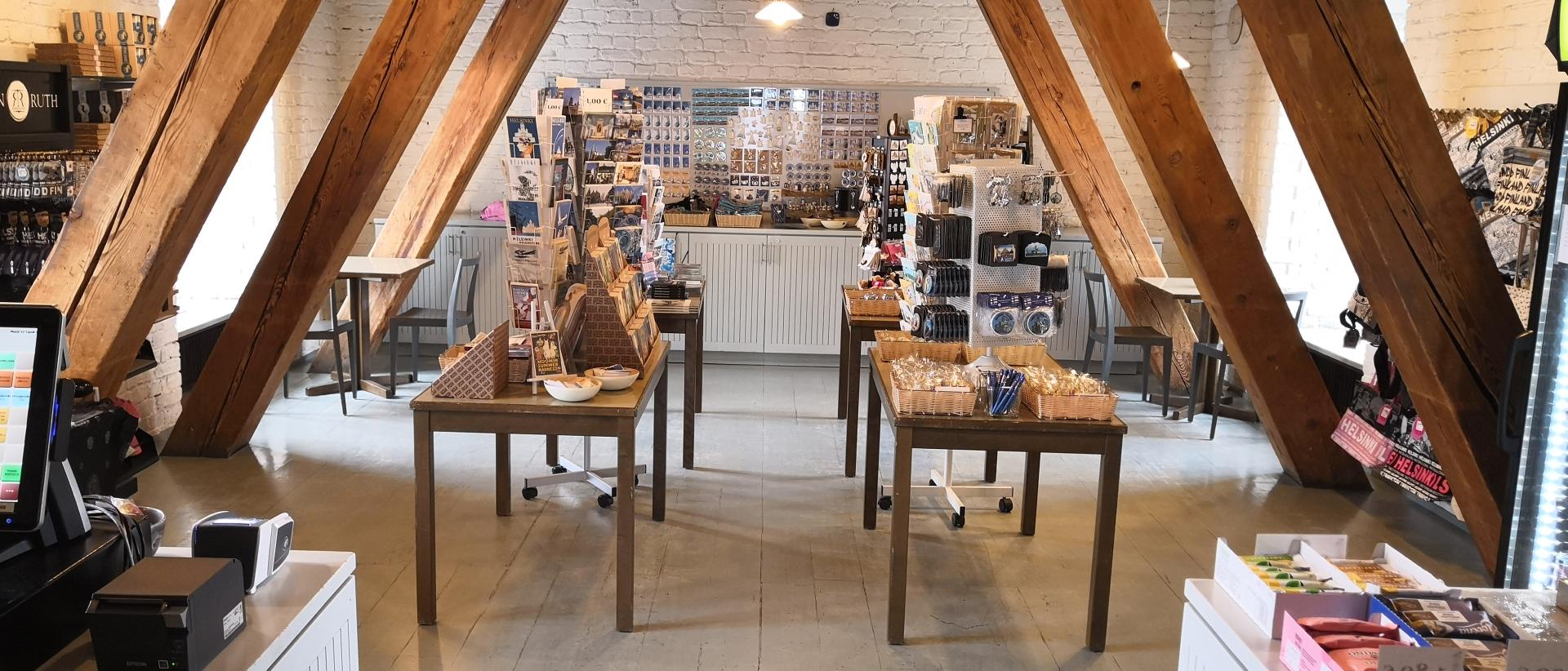Tuomiokirkkoseurakunnan Cathedral Shop-matkamuistomyymälä. Kuvassa pöytiä joilla erilaisia matkamuistoja, kuten kortteja ja avaimenperiä ja pikkutavaroita. Taustalla seinällä magneetteja.